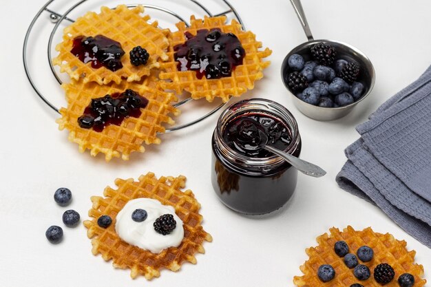 Een potje jam Wafels met jam en bessen op tafel Bessen in een kom