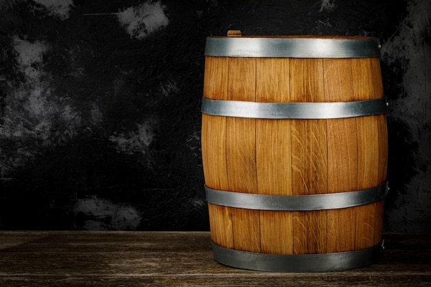 Een prachtig houten vat en een versleten eikenhouten tafel tegen een donker muurpatroon voor het ontwerp