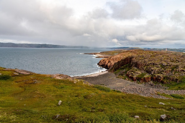 Een prachtig landschap van de Noordzeekust met stenen bedekt met kleurrijk mos. Uitzicht vanaf de berg.Teriberka, Barentszzee, regio Moermansk, schiereiland Kola