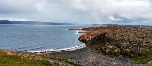 Een prachtig landschap van de Noordzeekust met stenen bedekt met kleurrijk mos. Uitzicht vanaf de berg.Teriberka, Barentszzee, regio Moermansk, schiereiland Kola