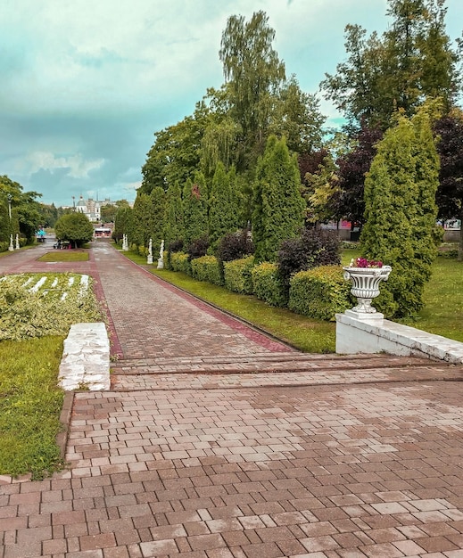 Een prachtig uitzicht op een stadspark met beelden en vazen langs een geplaveide loopbrug