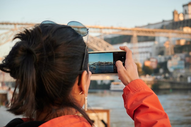 Een prachtige foto van een Spaans meisje dat een foto maakt van een stadsgezicht in Porto