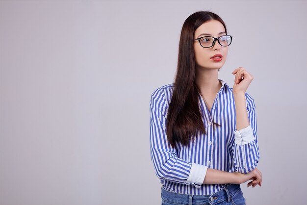 een prettige jonge mooie zakelijke vrouw staat in de zijkant te kijken