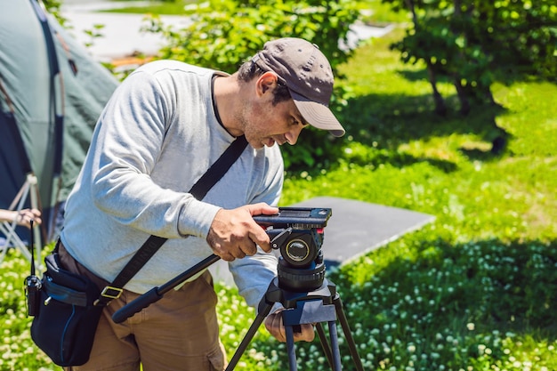 Een professionele cameraman bereidt een camera en een statief voor voordat hij gaat fotograferen