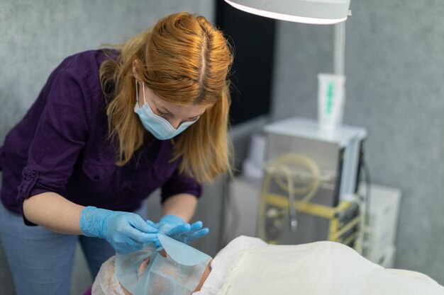 Een professionele cosmetoloog werkt nauwkeurig en zorgvuldig