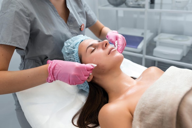 Een professionele schoonheidsspecialiste voert een mechanische gezichtsreinigingsprocedure uit in de spa Mooie blanke vrouw op een cosmetische procedure gezondheidscentrum