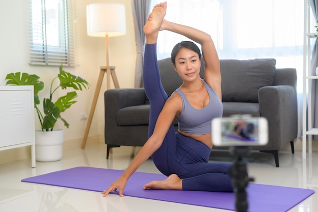 Een professionele yogacoach die online trainingslessen geeft aan studenten tijdens livestreaming