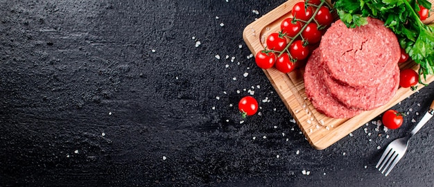 Een rauwe burger op een tomatensnijplank