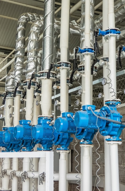Een reeks blauwe elektrische waterpompen. buizen en motoren in de industrie