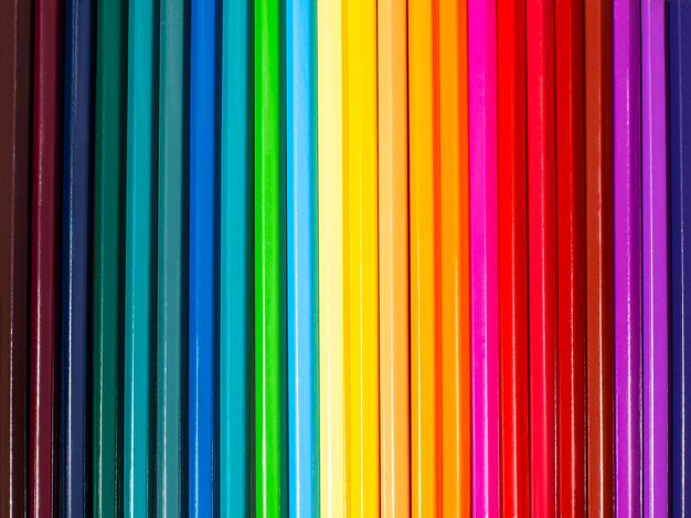Een reeks kleurrijke heldere potloden op een rij mooie heldere achtergrond