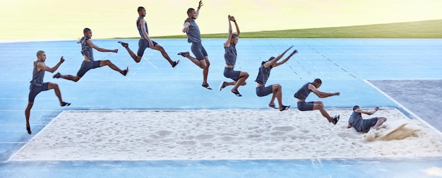 Een reeks van een fitte mannelijke atleet die in een zandbak springt die deelneemt aan het verspringen Professionele atleet of baanrenner tijdens een poging tot verspringen of hinkstapspringen is een competitief sportevenement of training