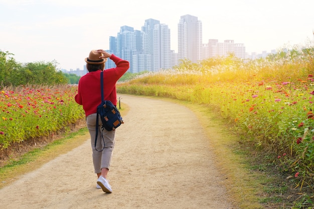 Een reiziger die in het bloemenpark naar het gebouw in Seoul Korea loopt