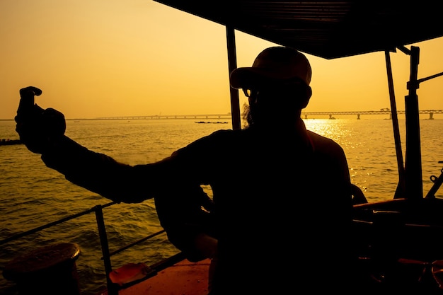 Een reiziger maakt foto's van de nieuw gebouwde multifunctionele Padma-brug met zijn smartphone in het tegenlicht