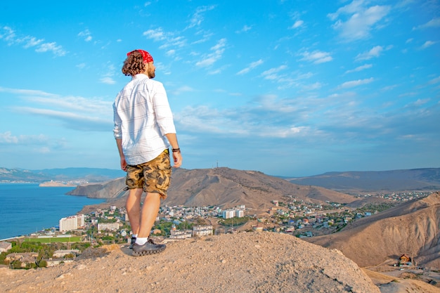 Een reiziger staat op de top van een berg en bewondert het landschap