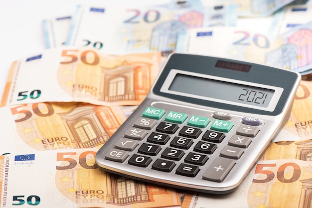 Een rekenmachine met eurogeld met belastingjaar 2021 year