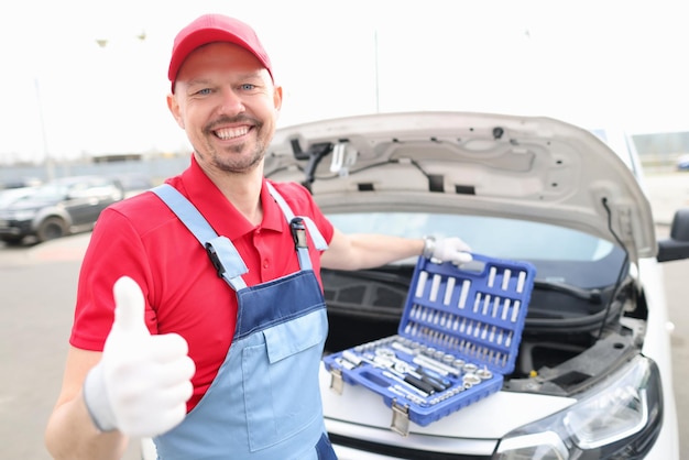 Een reparateur in een rood uniform opende de motorkap op straat