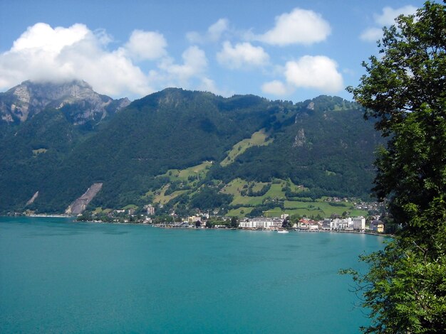 Een resort onder majestueuze bergen aan de oever van een turquoise zeebaai