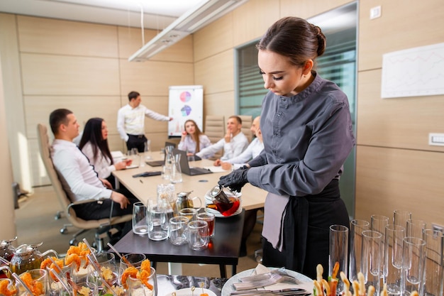 Een restaurantkelner serveert een extern banket in het kantoorxa