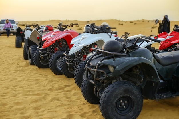 Een rij ATV's staat in oranje woestijnzand