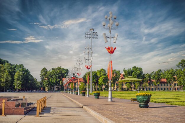 Een rij pilaren met Vietnamese vlaggen op het plein voor het mausoleum