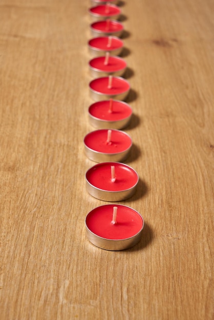 Een rij rode kaarsen op een houten tafel
