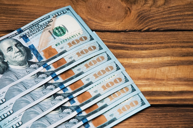 Een rij van contant geld honderd Amerikaanse bankbiljetten op houten.