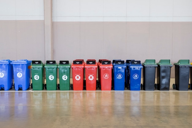 Een rij veelkleurige industriële plastic afvalcontainers.