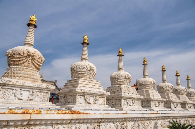 Een rij wit in Hohhot Binnen-Mongolië De stupas zijn rijkelijk versierd met gouden elementen Spiritualiteit en religie Blauwe hemel met kopieerruimte voor tekst