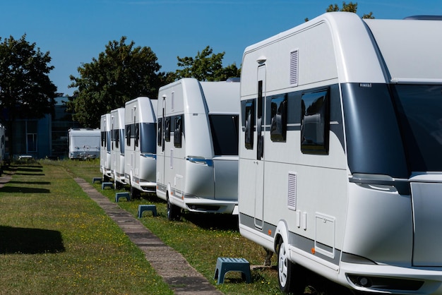 Een rij witte toercaravans staat op een zonnige dag in de zomer