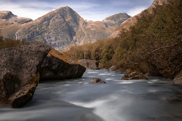 Een rivier in een wilde omgeving en enkele bergtoppen op weg naar de gletsjer briksdal in noorwegen