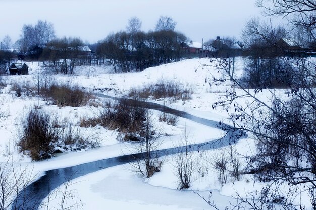 Een rivier op de achtergrond van een dorpswinter