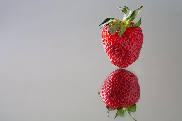 Een rode aardbei met groene blaadjes erop