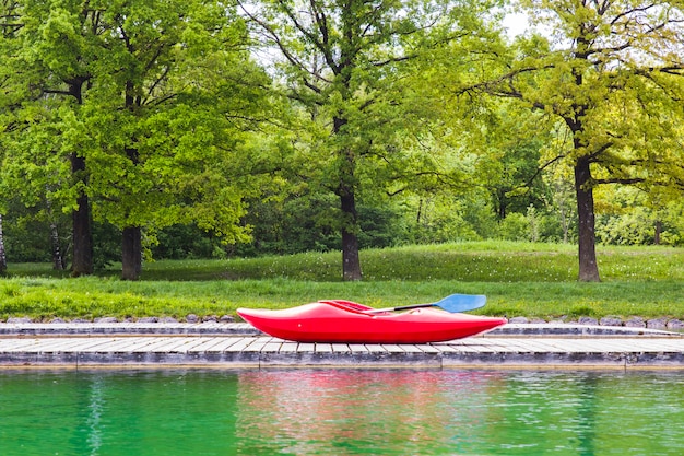 Een rode kajak op houten steiger in een meer