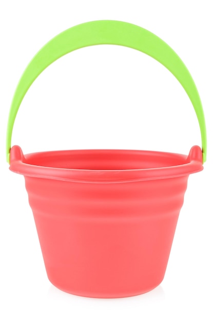 Een rode rubberen of plastic babyemmer met een groen handvat op een witte achtergrond Emmer om in de zandbak of op zee te spelen Kinderspeelgoed met ruimte voor uw label of merkmodel