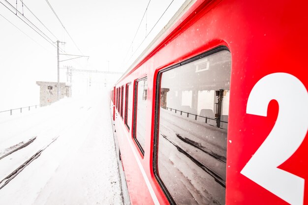 Een rode trein midden in een sneeuwwoestijn