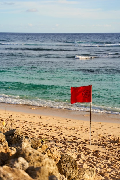 Foto een rode vlag is geplaatst op het oceaanstrand vanwege het risico op een mogelijke storm.