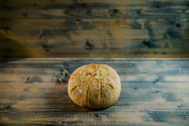 Foto een rond brood ligt op een houten tafel .