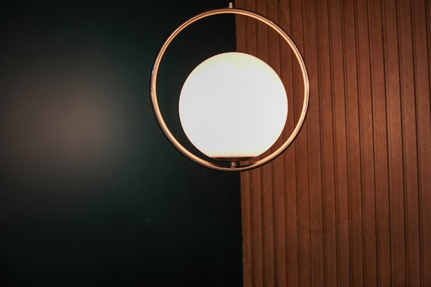 een rond licht hangt aan een houten muur