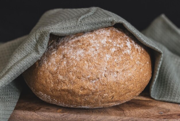 Een rond tarwebrood met vezels op een zwarte achtergrond