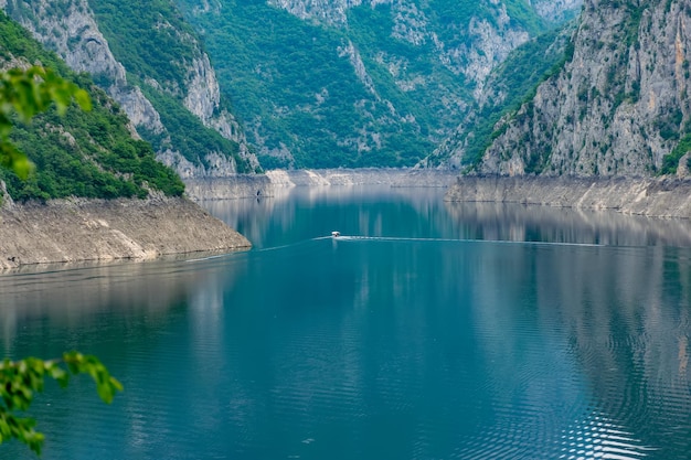 Een rondvaartboot met toeristen zwemt langs het schilderachtige meer tussen de kloof