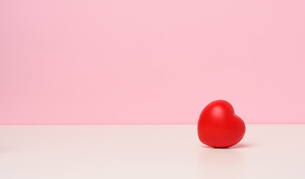 Een rood hart op een roze achtergrond, kopieer ruimte, Valentijnsdag