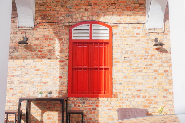 Een rood raam met het woord erop aan de zijkant van een bakstenen muur