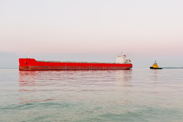 Foto een rood vrachtschip zeilt op zee.