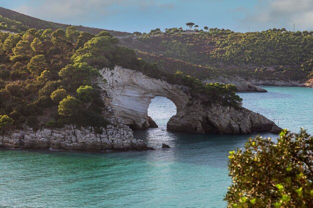 Een rotsformatie in het water met een klein eiland op de achtergrond De rotsachtige kust van de Adriatische Zee