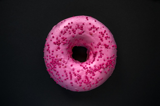 Een roze donut met roze hagelslag erop