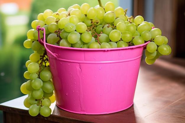 Een roze emmer vol groene zoete druiven foto van hoge kwaliteit