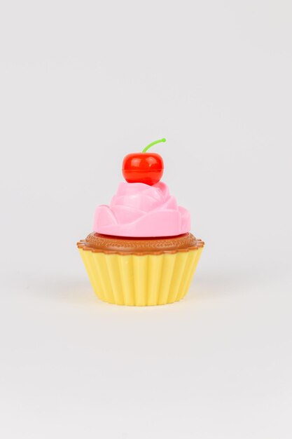 Een roze heerlijke taart met slagroom cupcake children39s plastic speelgoed op een witte achtergrond