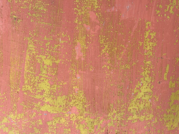 Een roze muur met gele verf en een groene achtergrond.