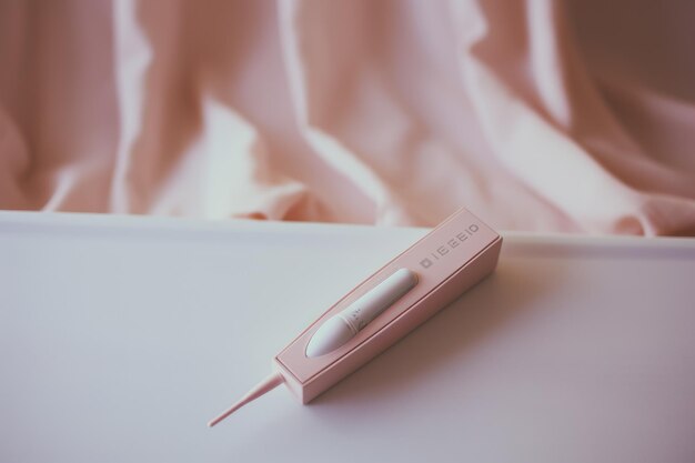 Een roze tandenborstel rust op een witte tafel die een essentieel hulpmiddel voor dagelijkse mondhygiëne benadrukt Vrouw die zwangerschapstest AI gegenereerd