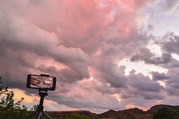 Foto een roze zonsondergang fotograferen op een smartphone in de bergen